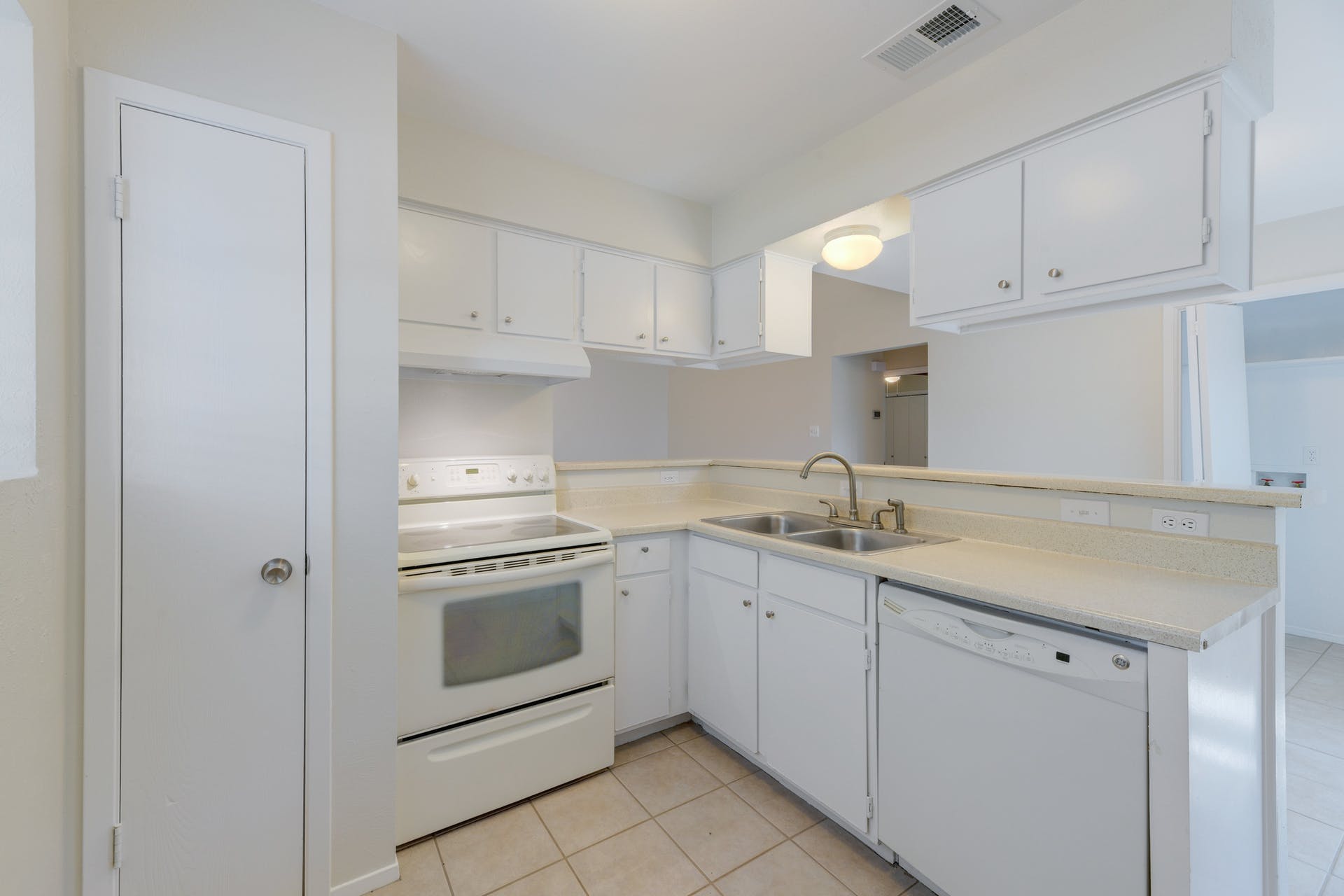 12603 Teague Trail, Unit B Austin, TX 78729 - Photo 8 of 14 a kitchen with white cabinets stainless steel appliances and sink
