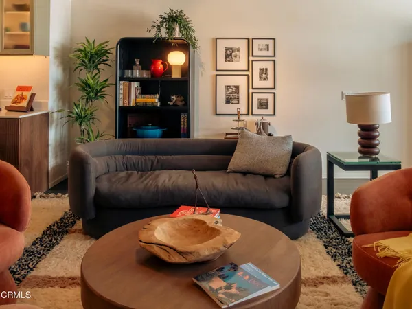 a living room with furniture and a painting on the wall