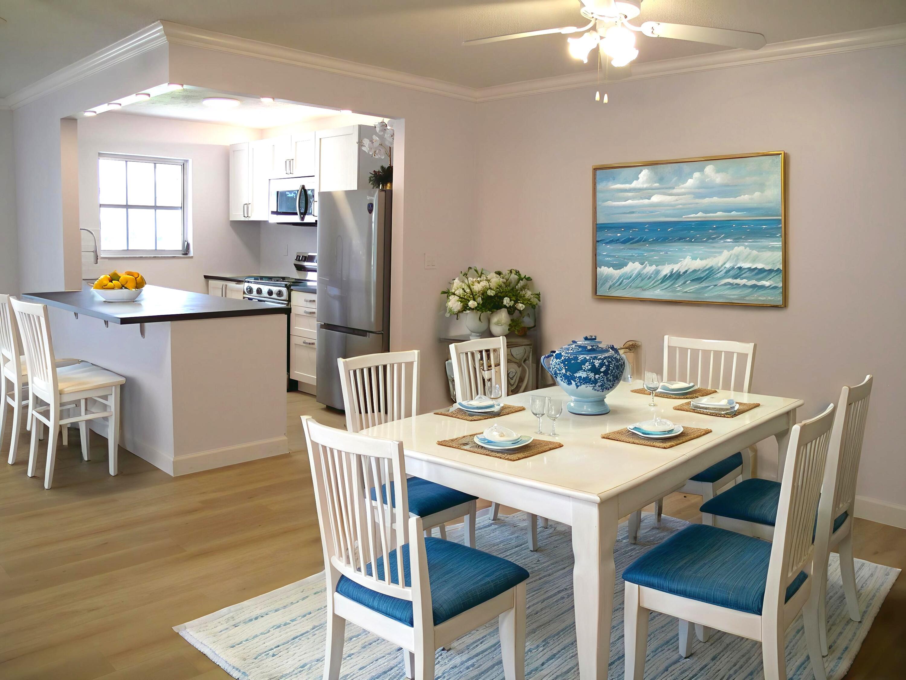 1102 North Drive, Unit C Delray Beach, FL 33445 - Photo 1 of 36 a dining room with furniture a kitchen view and wooden floor