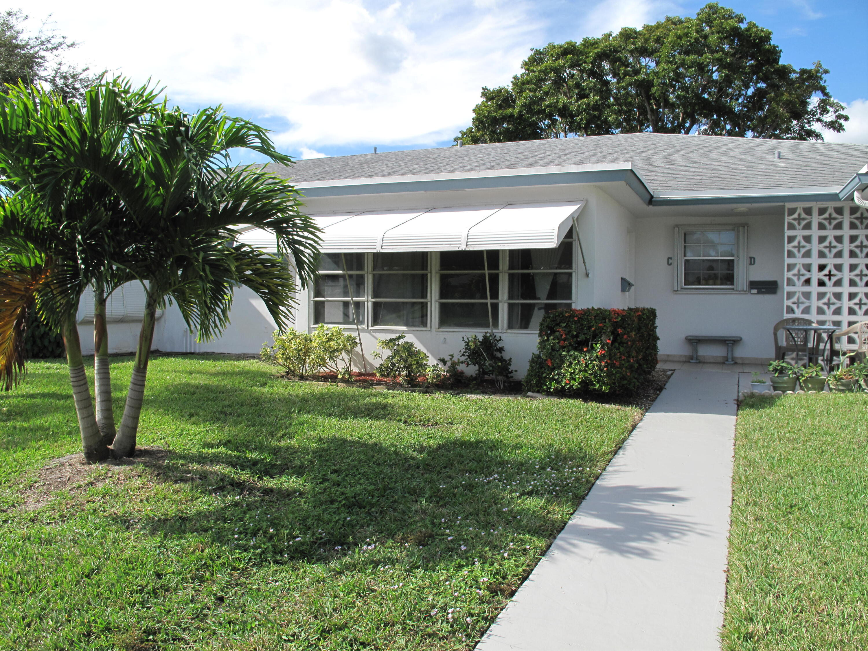 1102 North Drive, Unit C Delray Beach, FL 33445 - Photo 3 of 36 a view of a house with a yard and potted plants