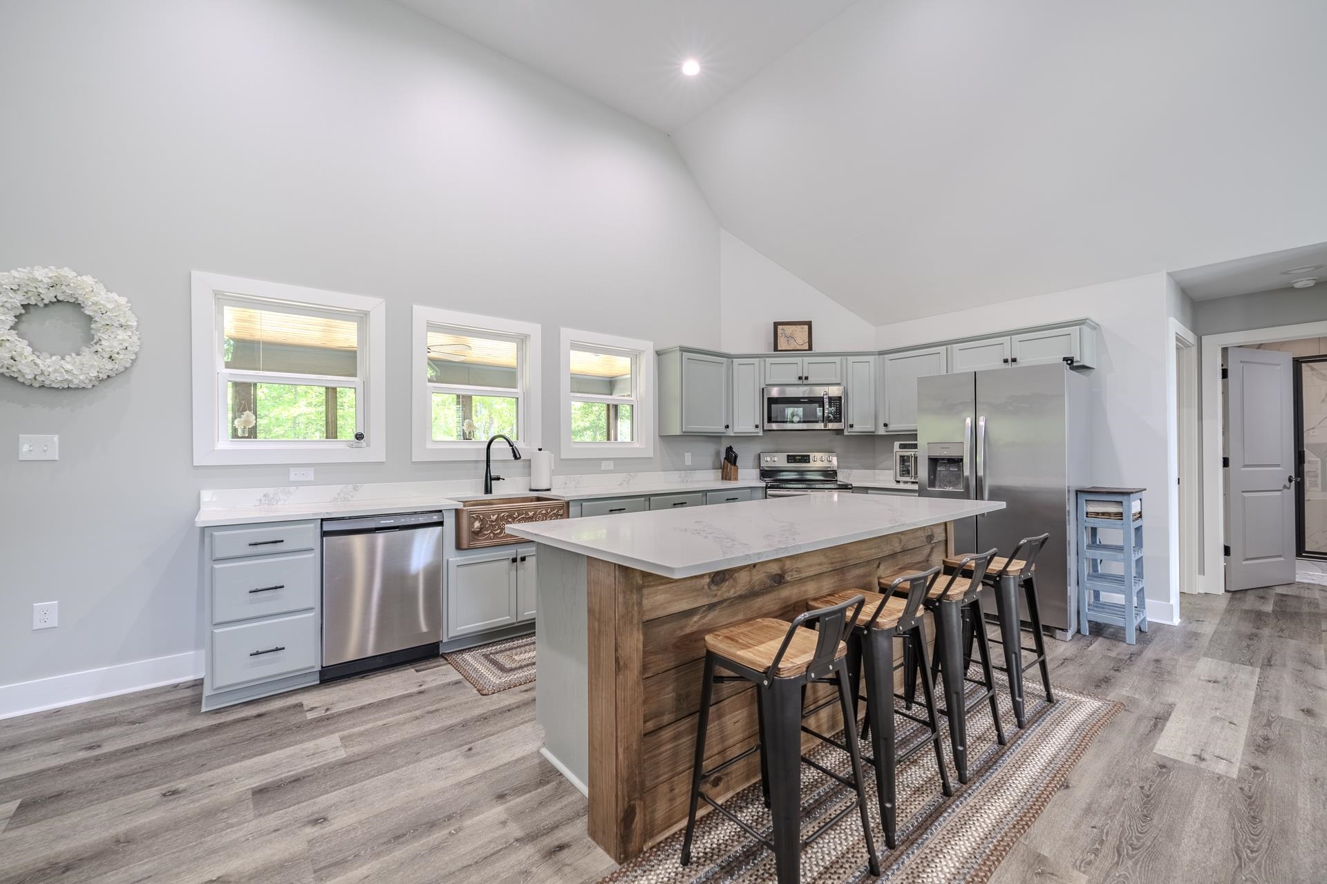120 Rustic Trail Counce, TN 38326 - Photo 15 of 29 Kitchen featuring a center island, stainless steel appliances, a breakfast bar, vaulted ceiling, and gray cabinets
