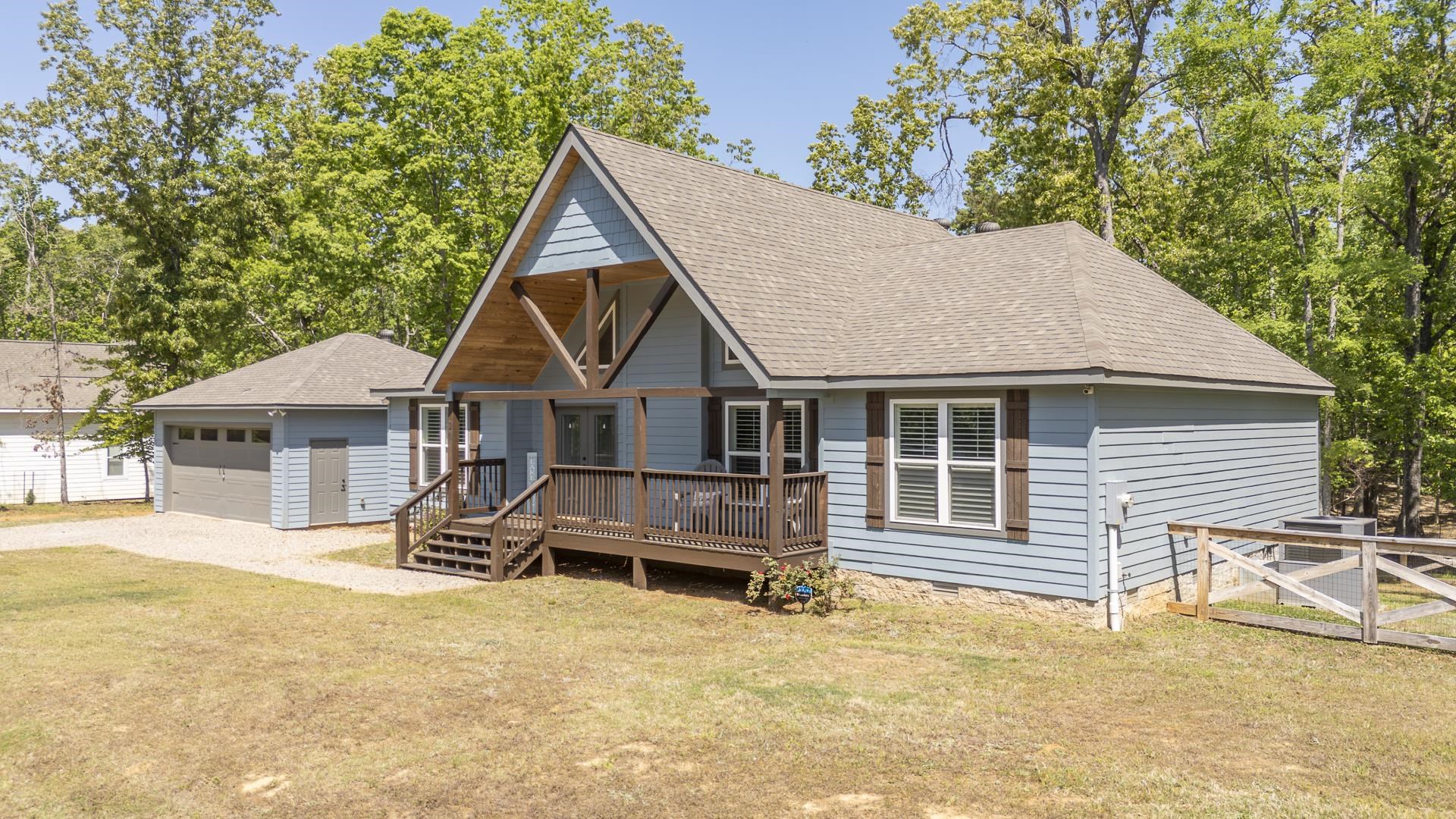 120 Rustic Trail Counce, TN 38326 - Photo 2 of 29 Rustic home with a shingled roof, a wooden deck, a front yard, and a garage