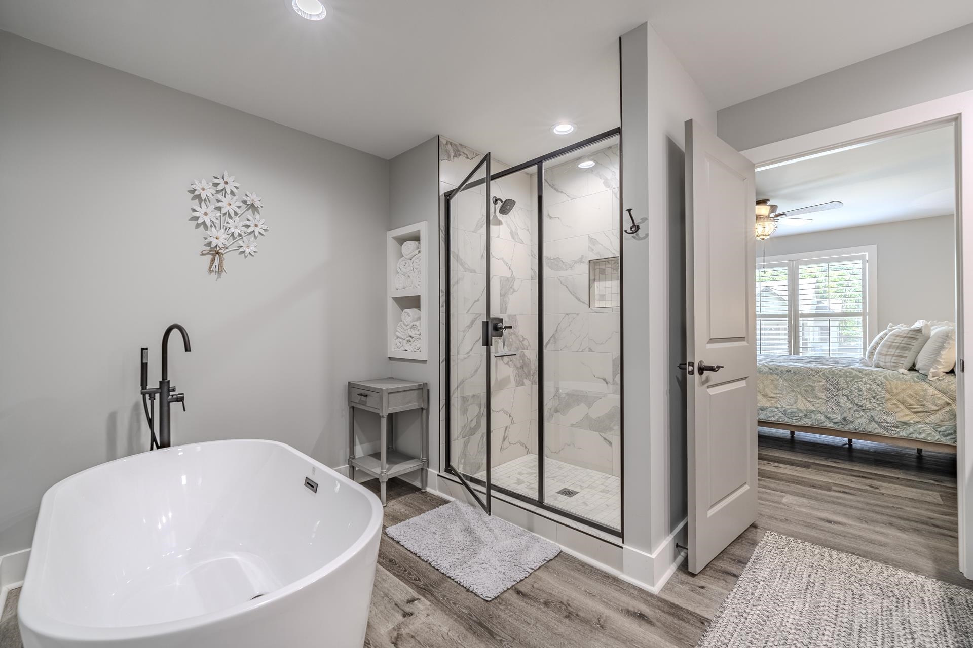 120 Rustic Trail Counce, TN 38326 - Photo 20 of 29 Full bathroom featuring light wood finished floors, ensuite bath, a marble finish shower, a freestanding tub, and a ceiling fan