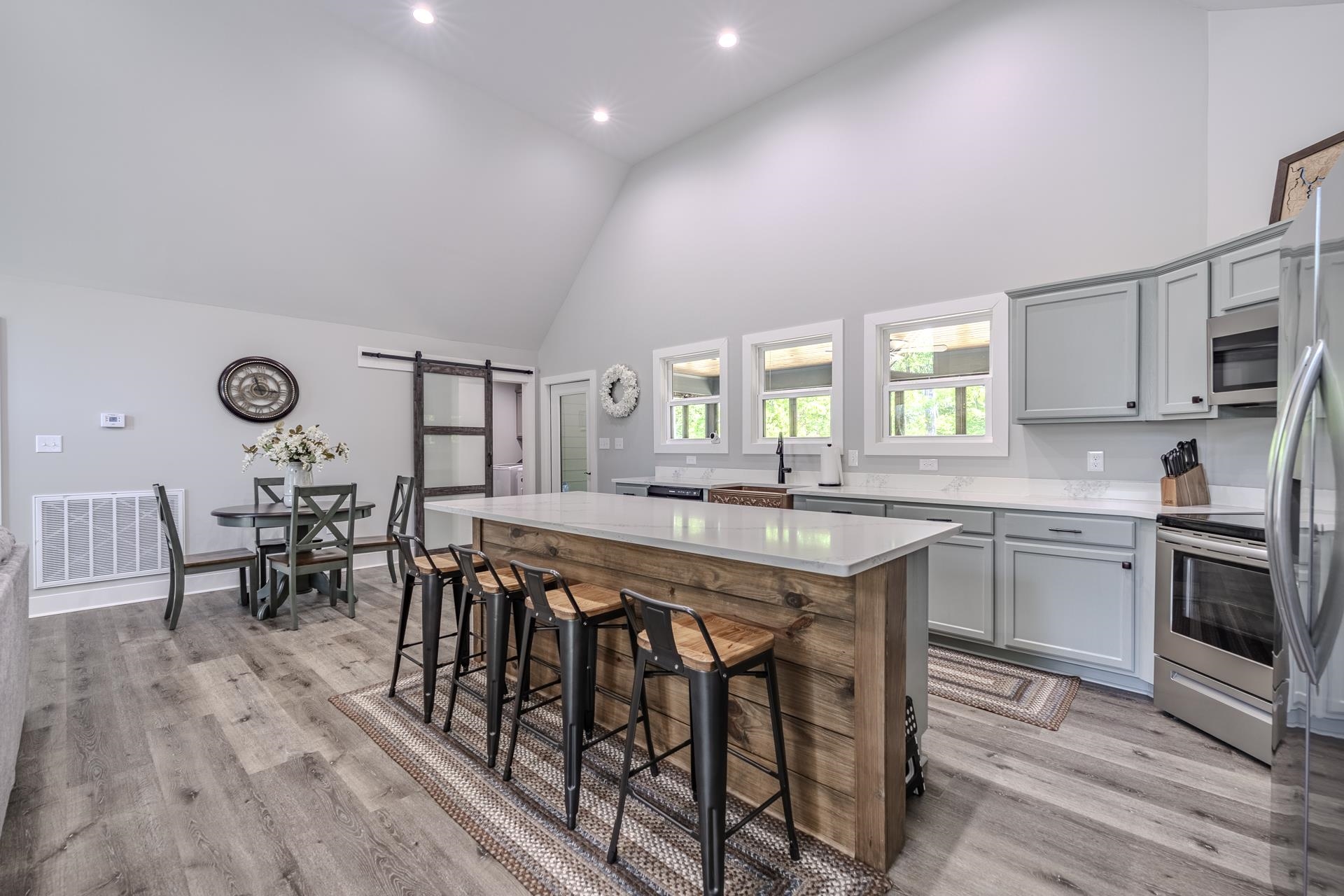 120 Rustic Trail Counce, TN 38326 - Photo 24 of 29 Kitchen with a barn door, gray cabinets, stainless steel appliances, light wood-style floors, and a kitchen breakfast bar