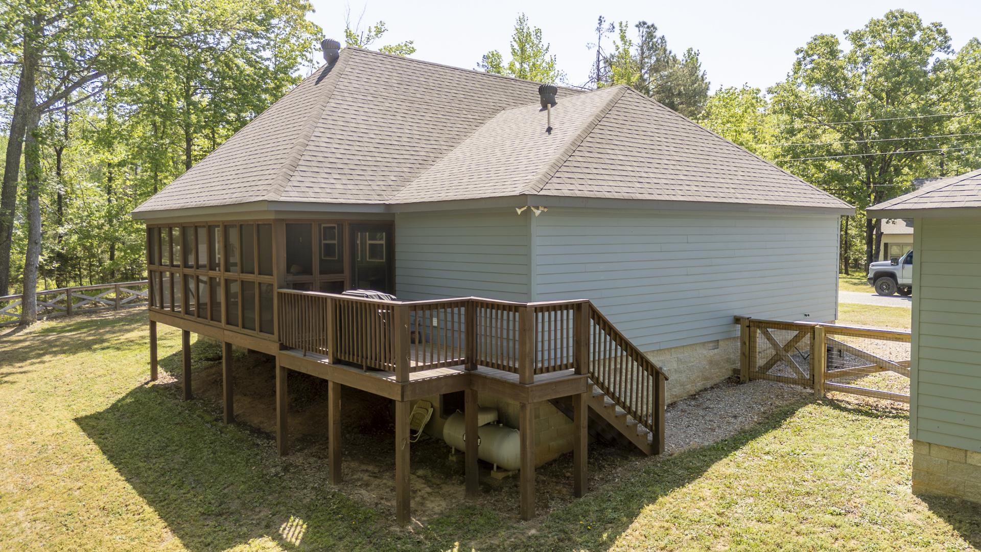 120 Rustic Trail Counce, TN 38326 - Photo 4 of 29 Back of property with a sunroom, a shingled roof, and a wooden deck