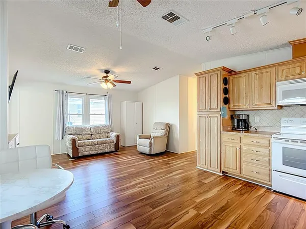 a living room with stainless steel appliances furniture or couch and a kitchen view