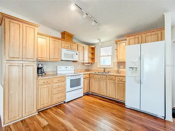 a kitchen with granite countertop white cabinets and white appliances