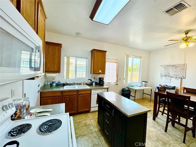 a kitchen with a stove a sink a dining table and chairs