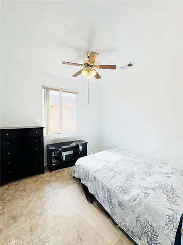 a bedroom with a bed and a ceiling fan