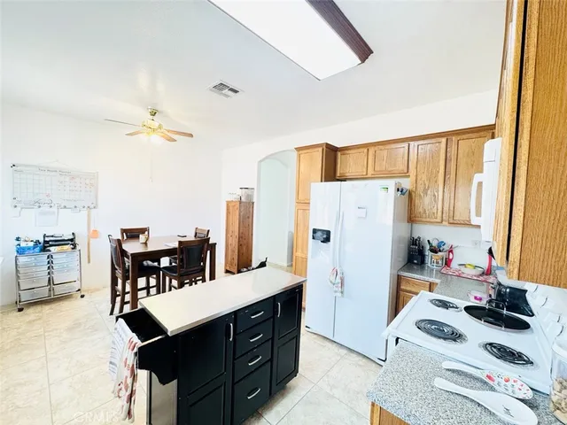 a kitchen with a refrigerator a stove a dining table and chairs with wooden floor