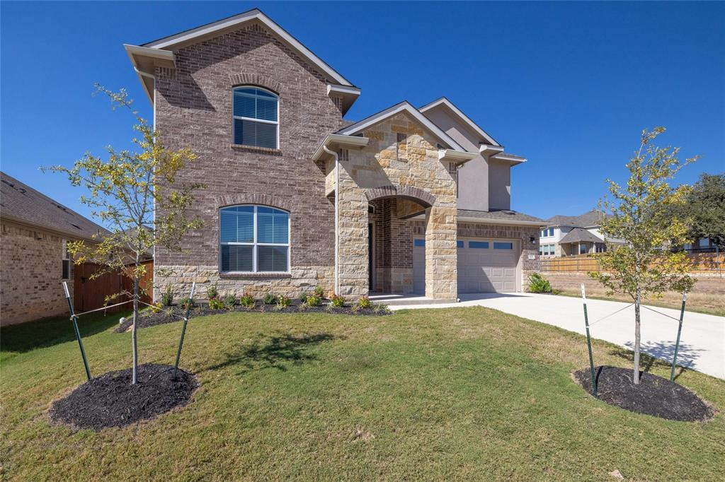 113 Shadow Oak Cove Georgetown, TX 78628 - Photo 2 of 40 A striking exterior combines brick and stone, creating an inviting front facade with an attached garage.