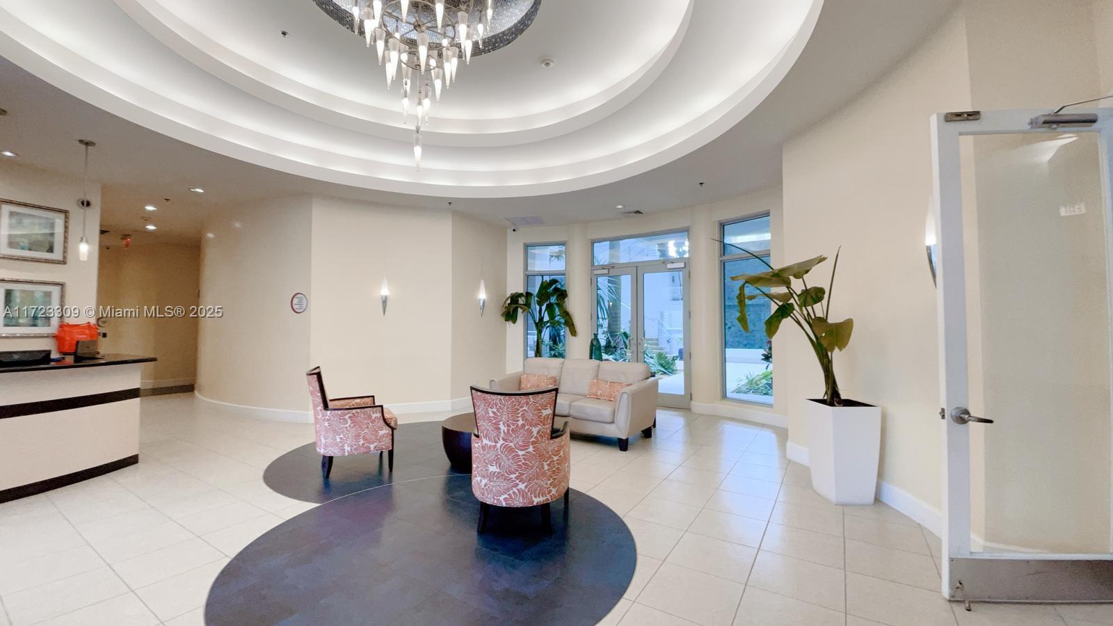 1830 Radius Drive, Unit 516 Hollywood, FL 33020 - Photo 16 of 28 a living room with furniture and a chandelier