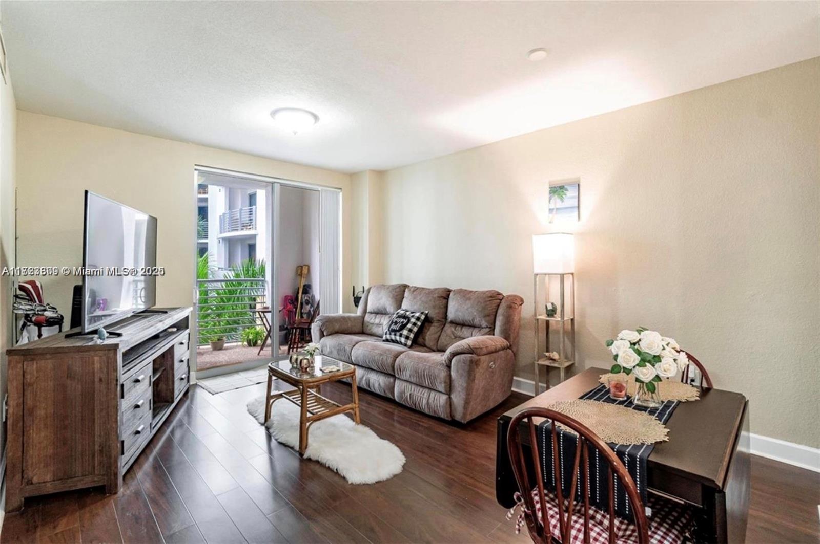 1830 Radius Drive, Unit 516 Hollywood, FL 33020 - Photo 21 of 28 a living room with furniture flat screen tv and a large window