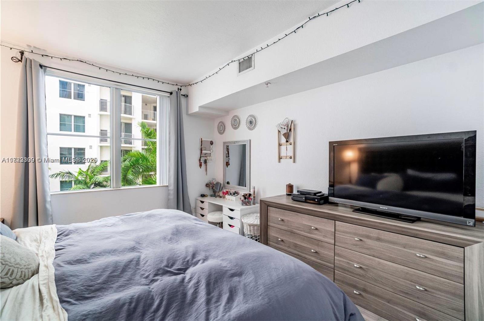 1830 Radius Drive, Unit 516 Hollywood, FL 33020 - Photo 27 of 28 a bedroom with a bed and a flat screen tv