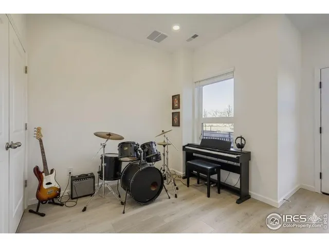 a living room with furniture a piano and a window