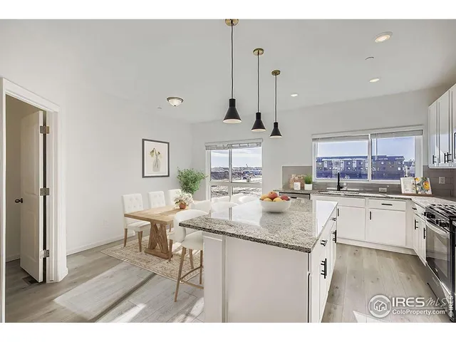a kitchen with stainless steel appliances granite countertop a sink dishwasher and white cabinets with wooden floor
