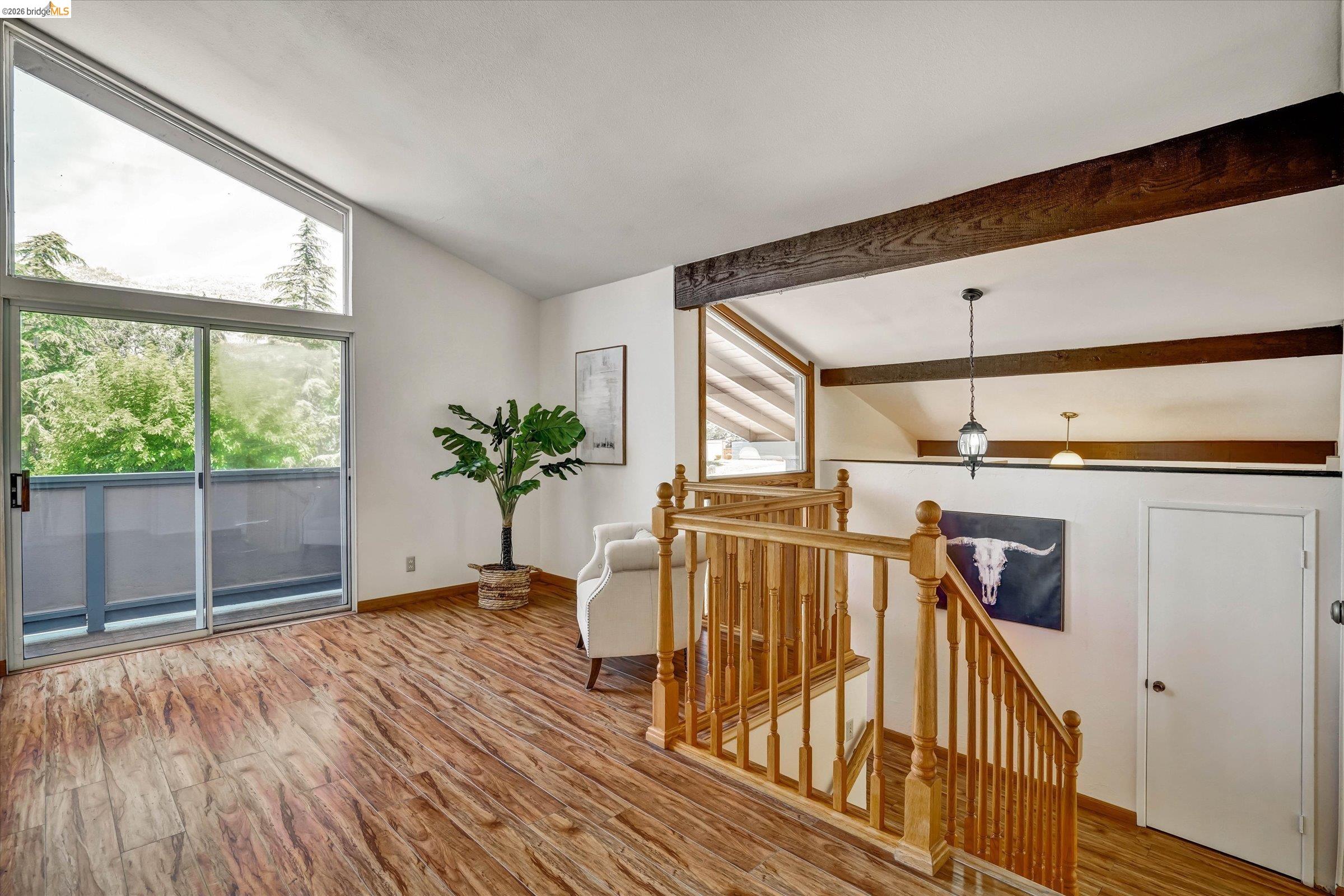 2826 Wright Avenue Pinole, CA 94564 - Photo 39 of 70 Vaulted ceiling with exposed wood beams, wood-finish flooring, and a sliding glass door leading to an outdoor balcony
