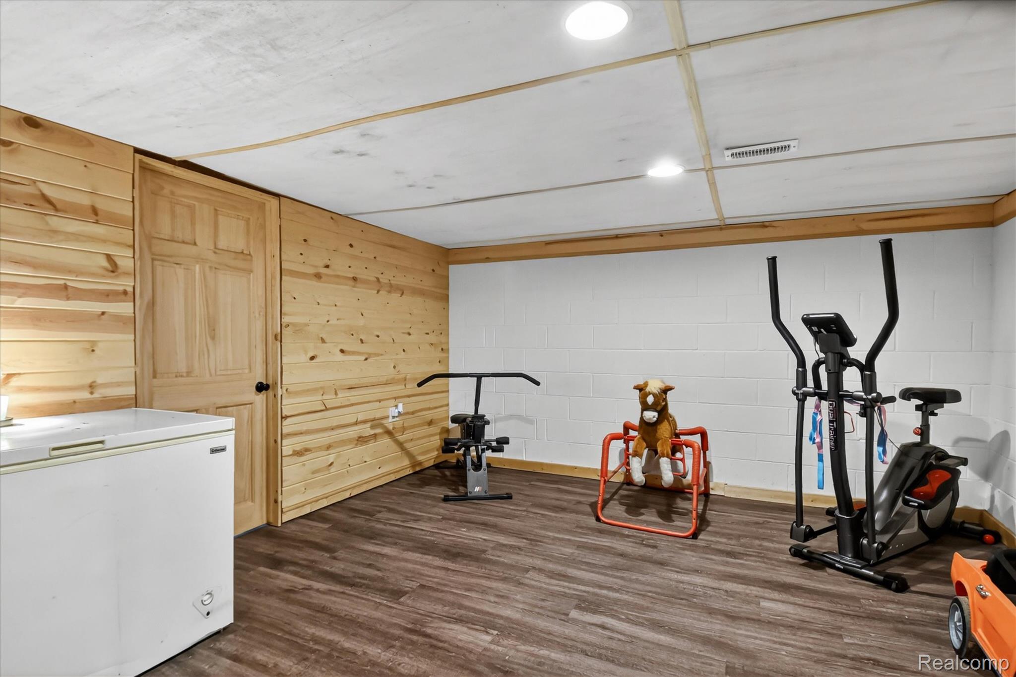 3949 West Burns Line Road Brown City, MI 48416 - Photo 50 of 70 Finished room featuring wood-finish flooring, recessed lighting, and a paneled wood accent wall