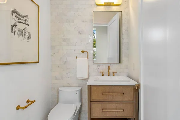 a bathroom with a sink vanity mirror and toilet