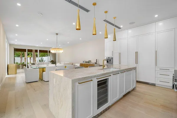 a large kitchen with stainless steel appliances a large counter top a stove a chimney a couches and kitchen view