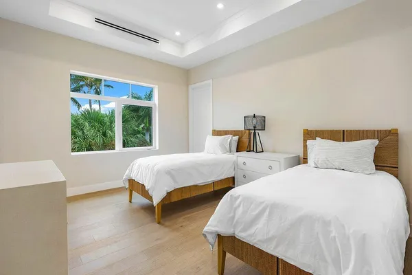 a bedroom with two beds and a large window