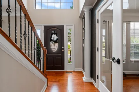 a view of a hallway with wooden floor and staircase