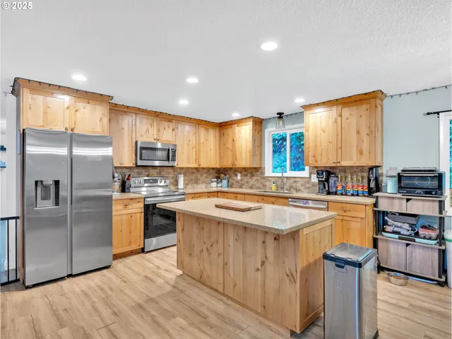 a kitchen with a sink a counter top space stainless steel appliances and cabinets