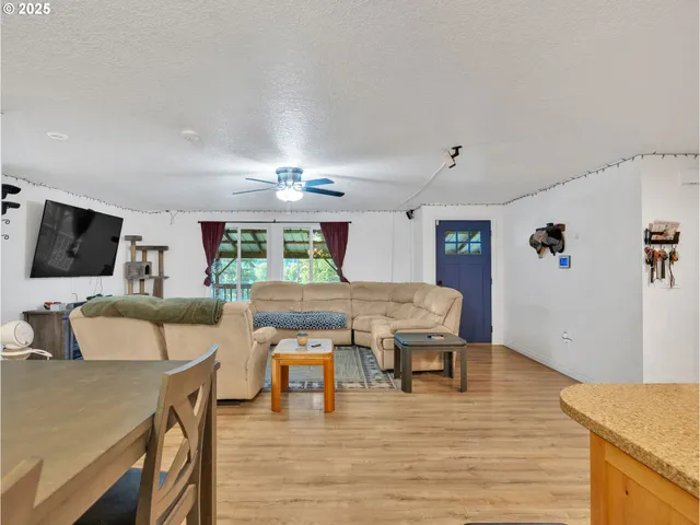 a living room with furniture a flat screen tv and a chandelier