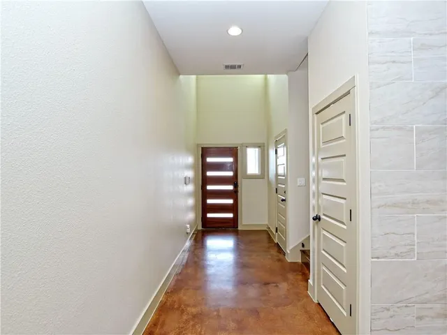 an empty room with fireplace wooden floor and windows