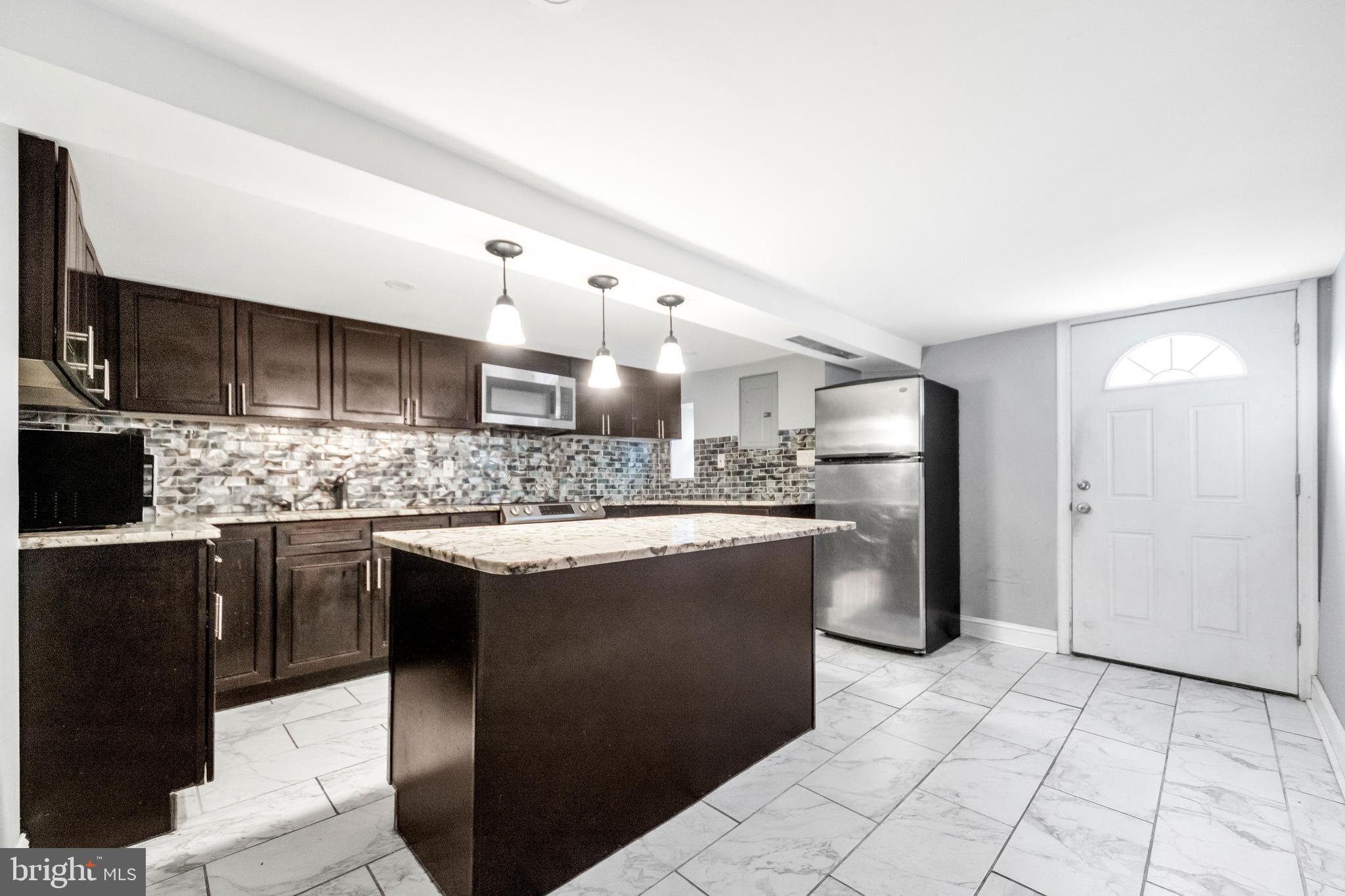 a kitchen with stainless steel appliances granite countertop a sink and a refrigerator