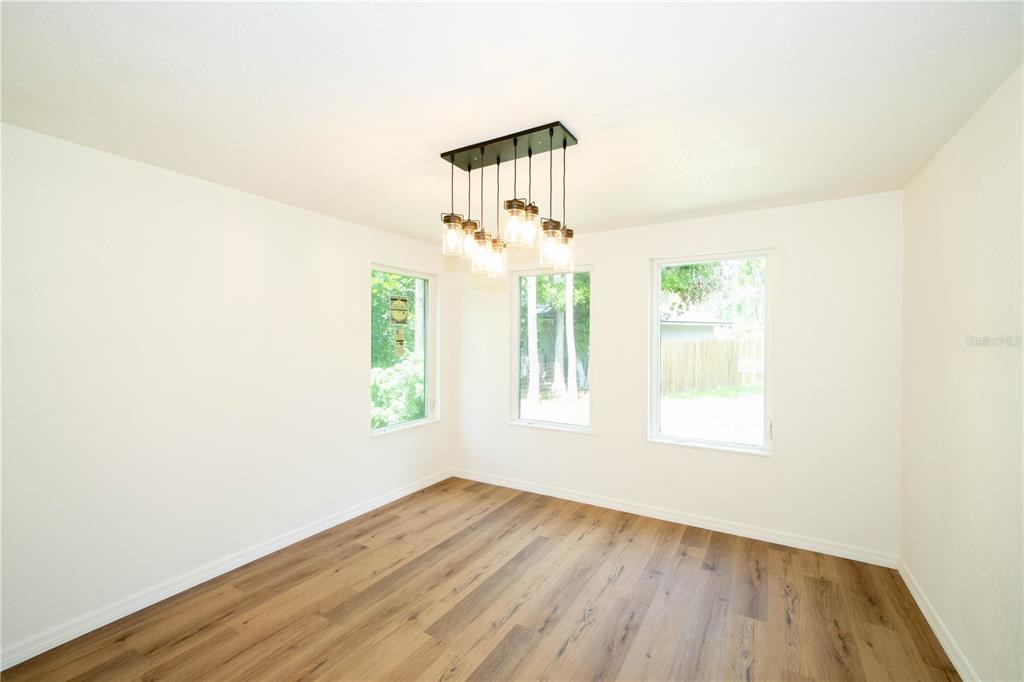 19003 Cedar Lane Lutz, FL 33548 - Photo 19 of 40 an empty room with wooden floor windows and a ceiling fan