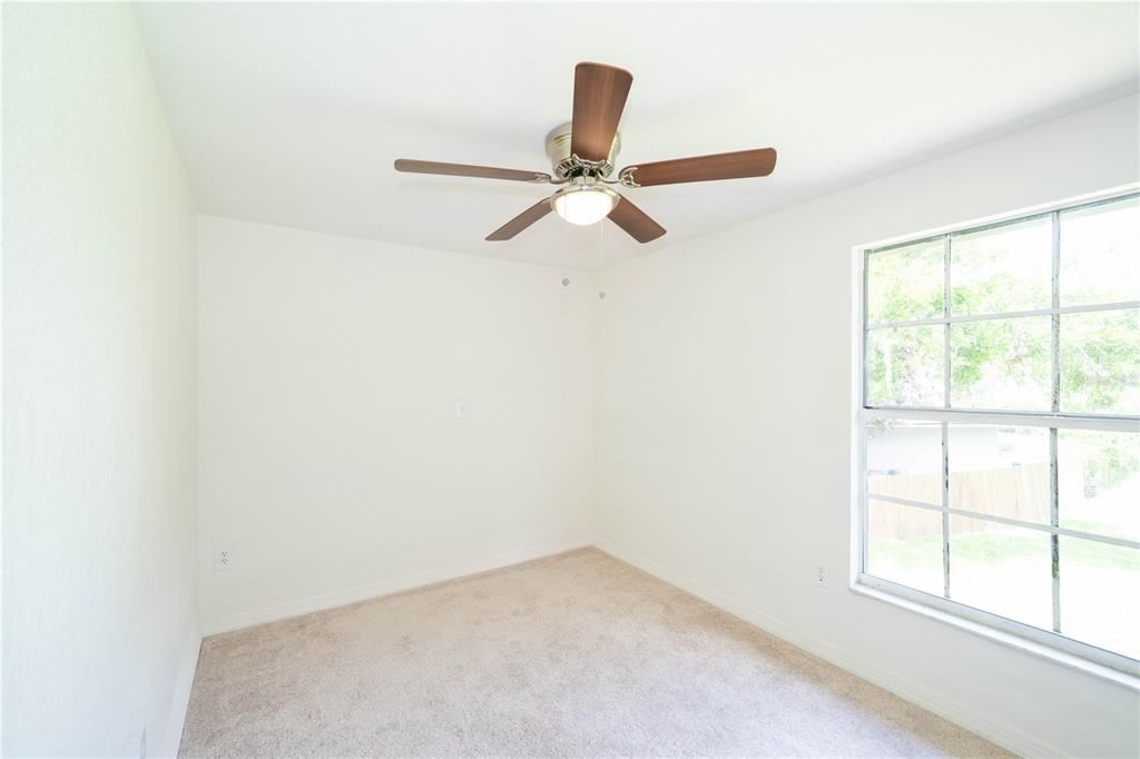 19003 Cedar Lane Lutz, FL 33548 - Photo 28 of 40 an empty room with a window and a fan