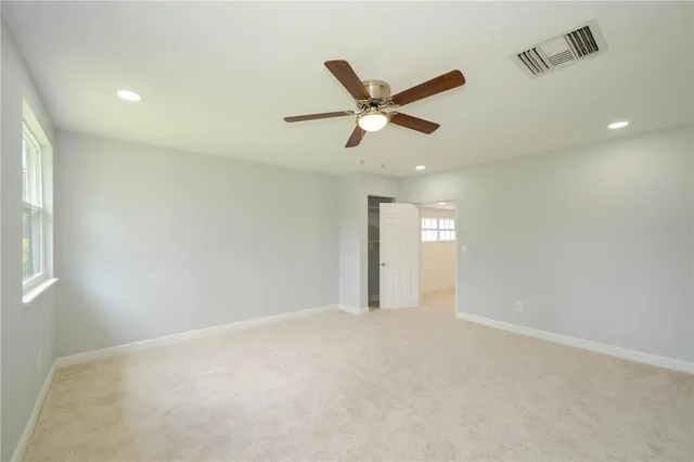 a view of an empty room with a ceiling fan