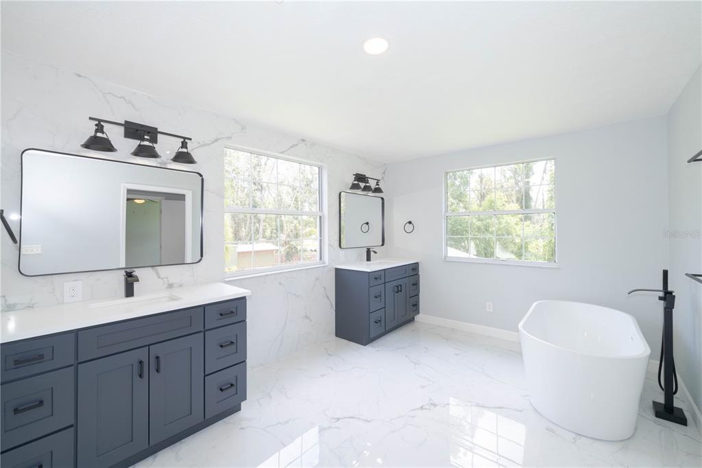 19003 Cedar Lane Lutz, FL 33548 - Photo 36 of 40 a spacious bathroom with a bathtub sink and mirror