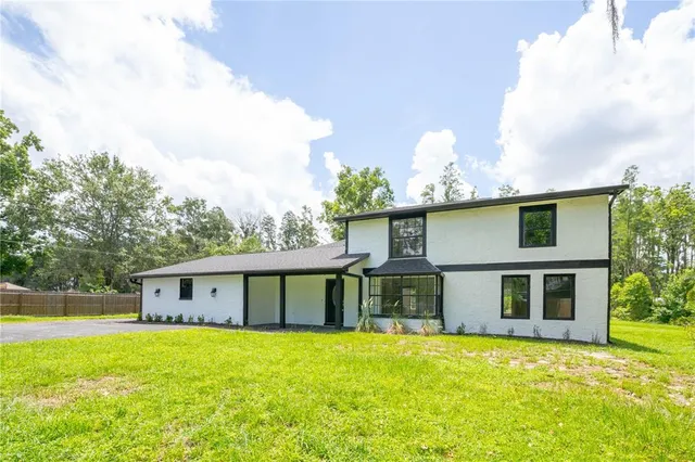 a front view of a house with a garden and yard