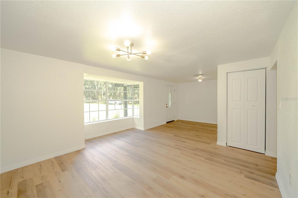 19003 Cedar Lane Lutz, FL 33548 - Photo 8 of 40 an empty room with wooden floor and windows
