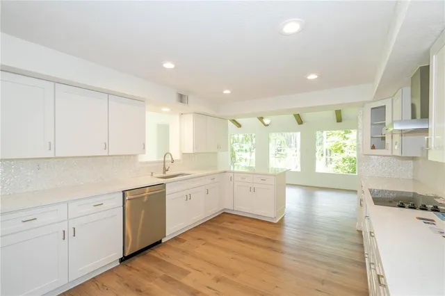 a large kitchen with stainless steel appliances kitchen island granite countertop a sink and cabinets