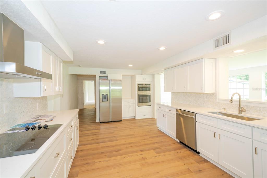 19003 Cedar Lane Lutz, FL 33548 - Photo 10 of 40 a large kitchen with stainless steel appliances kitchen island granite countertop a sink and cabinets