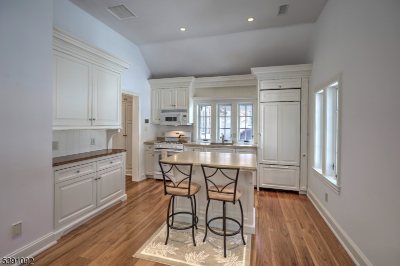 156 Overleigh Road Bernardsville, NJ 07924 - Photo 34 of 48 a kitchen with stainless steel appliances kitchen island wooden floors and white cabinets