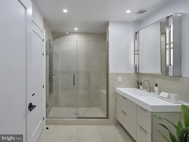 a bathroom with a shower sink and mirror