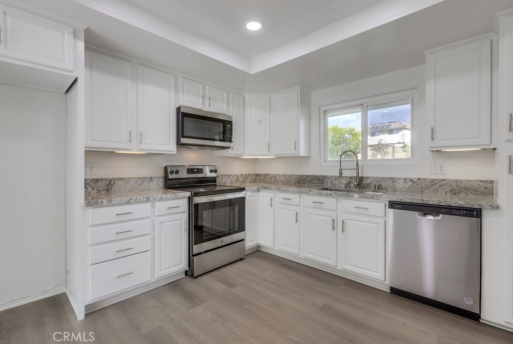 5429 Cajon Avenue Buena Park, CA 90621 - Photo 7 of 22 a kitchen with granite countertop white cabinets sink and stainless steel appliances