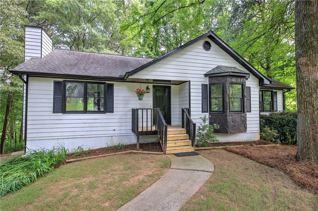 a view of a house with a yard and potted plants