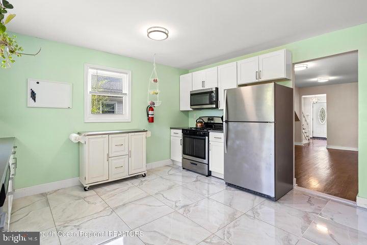 109 South Main Street Toms River, NJ 08757 - Photo 12 of 26 a kitchen with a refrigerator a stove top oven a counter space and cabinets