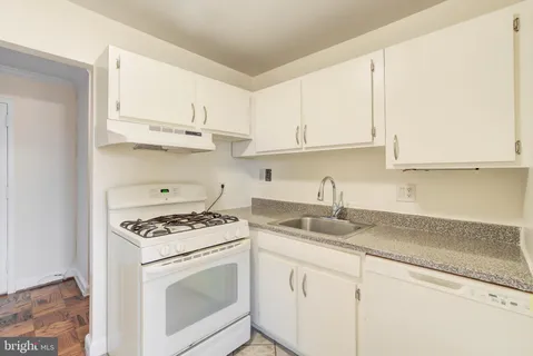 a kitchen with granite countertop white cabinets and white appliances