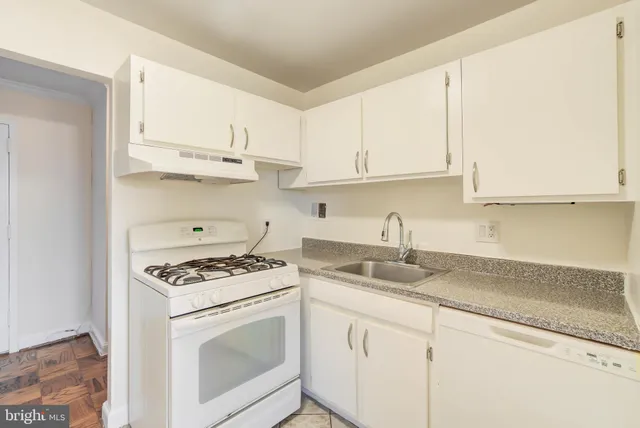 a kitchen with granite countertop white cabinets and white appliances