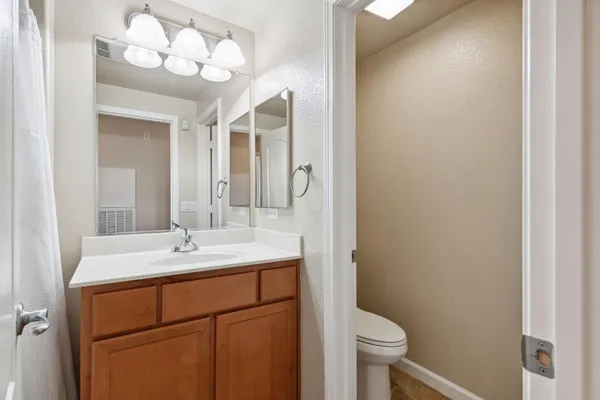 a bathroom with a sink vanity mirror and toilet