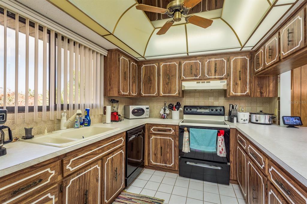 9910 Eagles Point Circle, Unit 3 Port Richey, FL 34668 - Photo 13 of 25 a kitchen with stainless steel appliances granite countertop a sink and cabinets