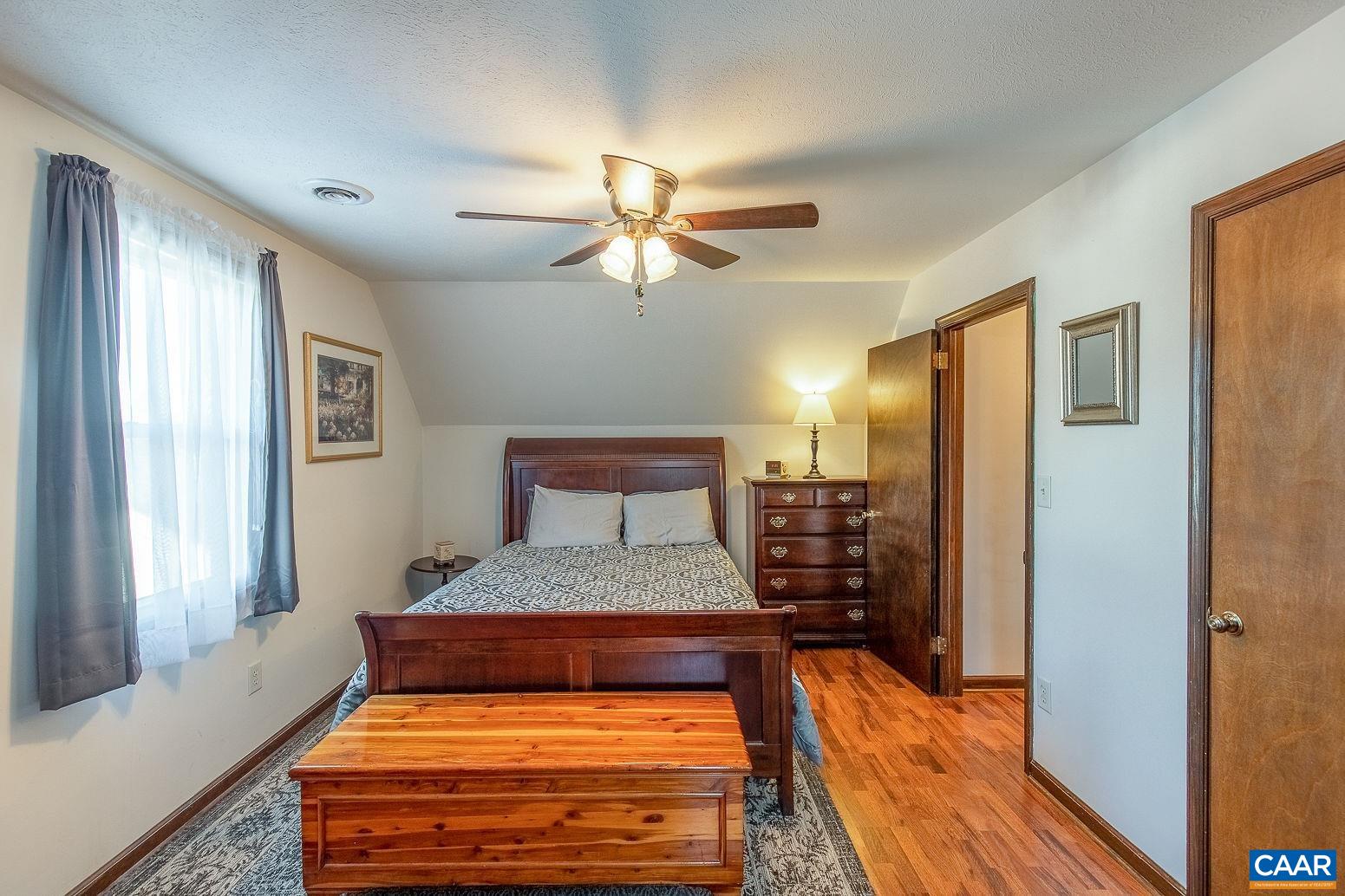 3248 Welsh Run Road Ruckersville, VA 22968 - Photo 23 of 43 a bedroom with a large bed and a chandelier