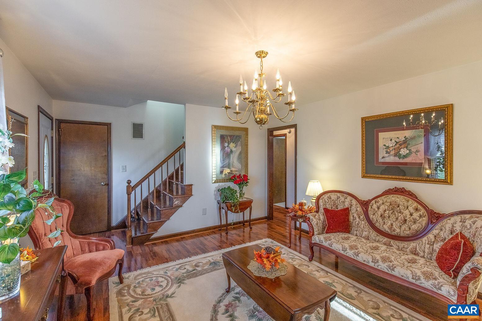 3248 Welsh Run Road Ruckersville, VA 22968 - Photo 5 of 43 a living room with couches chandelier and a dining table with garden view