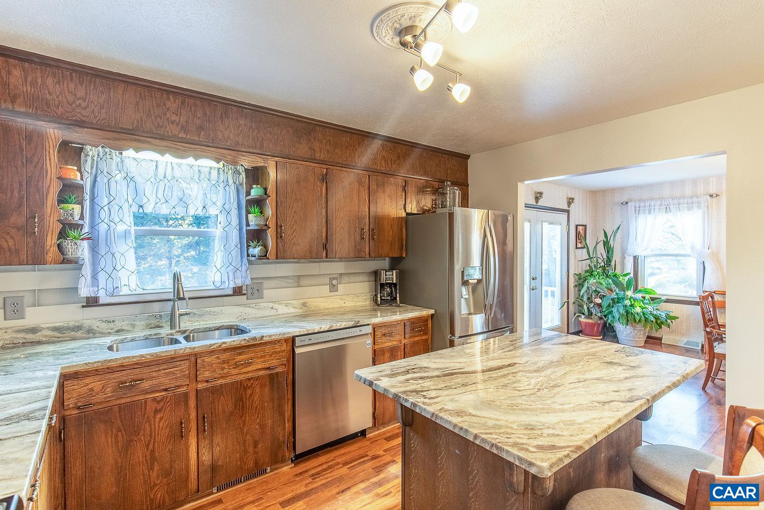 3248 Welsh Run Road Ruckersville, VA 22968 - Photo 8 of 43 a kitchen with kitchen island granite countertop a sink stainless steel appliances cabinets and furniture